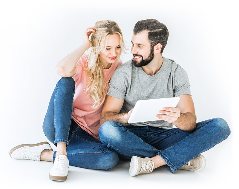 couple femme blonde homme cheveux et barbe brune tenant une tablette d'ordinateur et se souriant