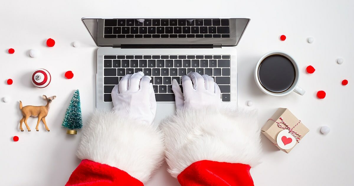 Père-Noël qui fait des achats en ligne sur un ordinateur